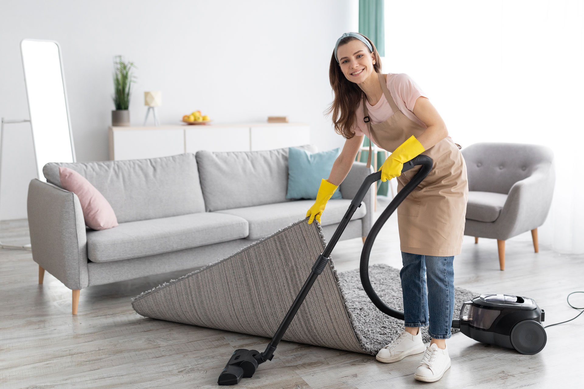 positive female housekeeper using vacuum cleaner MMHDNG5